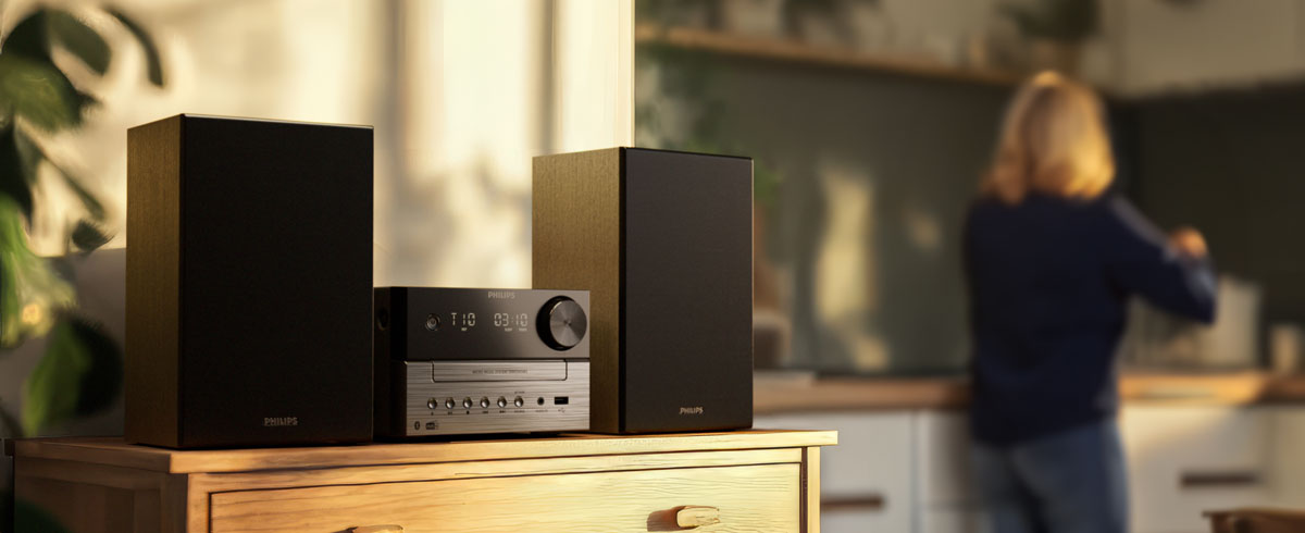 Women are listening to music in the kitchen using a Philips music system