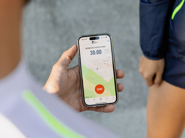 A participant in the run is checking their phone, waiting for the start to run.